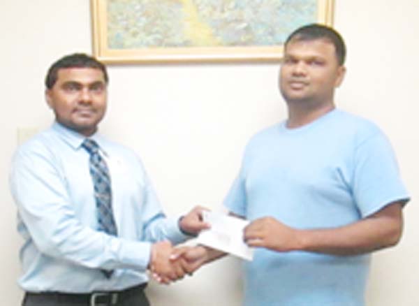 Mohamed Azim, Assistant manager of Scotia Bank presents cheque to RHTYSC, MS Executive member Mark Papannah.