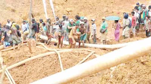 File photo: Rescuers remove a dead mining worker from a pit cave-in last year in Region Eight.