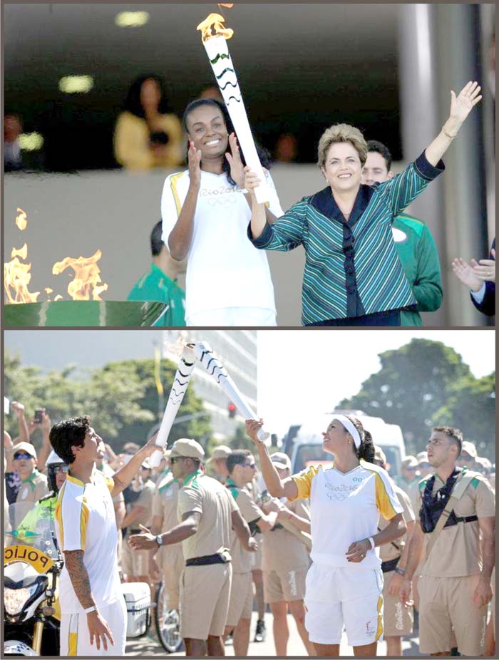 (Above) Brazil’s President Dilma Rousseff (R) waves after lighting a cauldron with the Olympic Flame next to Fabiana Claudino, captain of the Brazilian volleyball team, during the Olympic Flame torch relay at Planalto Palace in Brasilia, Brazil, May 3, 2016. (REUTERS/Ueslei Marcelino) (Below) Surfer Gabriel Medina (L) hands over the Olympic Flame to volleyball player Paula Pequeno as they take part in the Olympic Flame torch relay in Brasilia, Brazil, May 3, 2016. (Andrea Morao/Rio2016/Handout via Reuters)