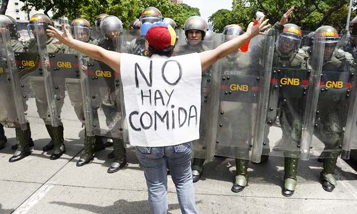A woman with a sign reading ‘There is no food’ protests against new emergency powers decreed by President Nicolás Maduro on 18 May.