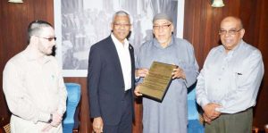 President David Granger receives the plaque from President of the CIOG, Al Hajj Fazeel M. Ferouz, while Sheik Moen ul-Hack (left) and Khakan Ramjohn look on.