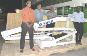 Director of Sport, Christopher Jones (right) and CBC VP, Patrick Haynes (left) along with NSC Officials that included GABF President, Nigel Hinds stand in one of the crates that housed level 1 FIBA certified basketball equipment at the Cliff Anderson Sports Hall.