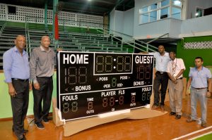 Officials from the LOC for the CBC U-16 Championships, George Vyphuis (left), GABF Head, Nigel Hinds, DoS, Christopher Jones and Japarts’ Terry Singh (right) take a photo opportunity at the mega new Shot Clock that will be erected at the Cliff Anderson Sports Hall.