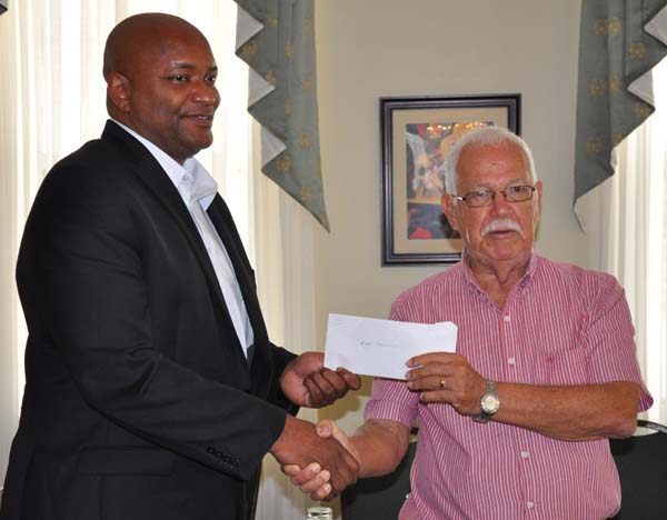 Veteran broadcaster and former basketball head in the ‘60s, Joseph ‘Reds’ Perreira (right) hands over his donation to current GABF President, Nigel Hinds yesterday at Cara Lodge.