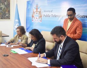 Minister of Public Telecommunications, Catherine Hughes, (Centre) ; UNDP’s Resident Representative, Khadija Musa (Left); and a representative of Detecon International GmbH, Stephan Dieter, signing the contract to kick off the Needs Assessment project yesterday at Colgrain House, Georgetown.
