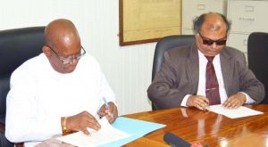 Minister of Finance Winston Jordan and Fedders Lloyd Country Representative, Ajay Jha, during the MOU signing last year November. 