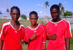 Morgan Denny is flanked by Dwayne St. Kitts (right) and Jermaine McDonald - Pouderoyen FC.