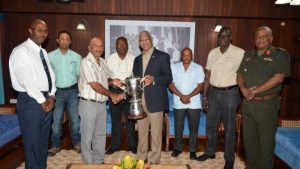 President David Granger being presented with the championship trophy by the GNRA’s Captain, Mahendra Persaud, while members (from L-R) Ryan Sampson, Dylan Fields, Lennox Braithwaite, Terrence Stuart, Paul Slowe and Brigadier General Mark Phillips look on.