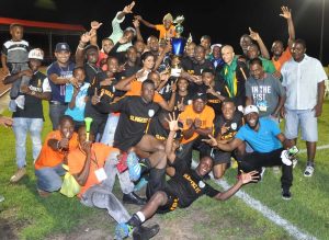 Hail the SEL Overall Champions! Director of Sport Christopher Jones and Ansa McAl’s Trade Marketing Manager Ms Darshanie Yussuf present the winning trophy to Slingerz Captain Tichard Joseph as his teammates and supporters savor the moment.    