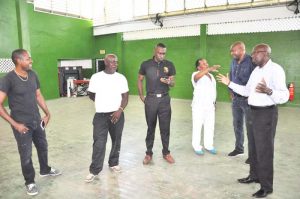 GABF President, Nigel Hinds (second, right) listens as NSC Chairman, Ivan Persaud makes a point at the Cliff Anderson Sports Hall yesterday on a visit to the facility. Also in photo are LOC Chairman, Alex Graham and Director of Sport, Christopher Jones and contractors.