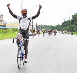 Unstoppable! Orville raises his hands in triumph as to signal victory in the 17th annual Castrol Father’s Day road race  yesterday.  (Franklin Wilson  photo) 