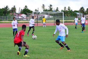 Players from West Demerara and Patentia fight for possession of the ball in their clash yesterday at the Leonora Synthetic Track facility.