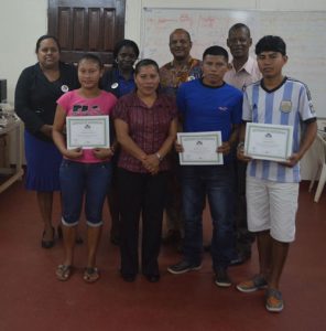 Back Row L-R–AREO Fitzpatrick, lecturer Vincent, REO Parker and coordinator of the Community Radio in Region 9. Front row, the graduating students are flanked by a Parisharra community councilor, Ms. Erlene Mc Donald.