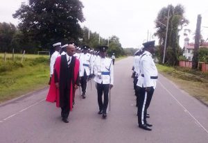 Justice Brassington Reynolds inspects the Guard of Honour accompanied by Commander Ian Amsterdam.