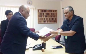 Minister of Natural Resources, Raphael Trotman receiving the CoI report from Major General (ret’d) Joe Singh yesterday.