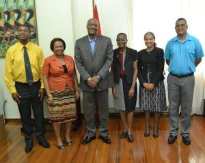 Minister of State, Joseph Harmon, with National Awardees who are staffers of the Ministry of the Presidency.