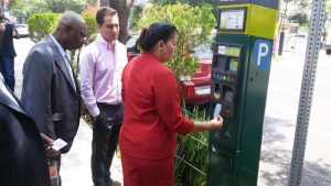 Mayor Patricia Chase-Green checking out one of the parking meters. At left is Councillor, Oscar Clarke.