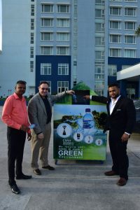 Marriott’s Richard E. Kasofsky (centre) and Jonathan Morgan drop the first bottles to be recycled into the bin donated by Ricky Lucknauth (left) of Clear Waters.