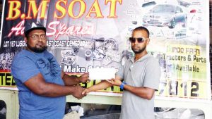 Mr Rovin De Souza (right) of the Guyana Cup 10 Anniversary organising Committee receives the sponsorship cheque from a representative of BM Soat Auto Spares.