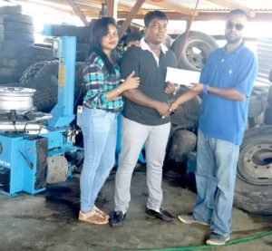 Mr and Mrs Ramsammy (left) presents the cheque to Rovin DeSouza of the Guyana Cup Organizing Committee. 