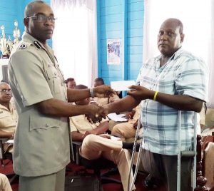 Commander Assistant Commissioner Ian Amsterdam hands over cheque to Etalemy Blackman