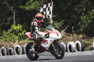  Guyana’s Matthew Vieira seen with chequered flag after winning one of three races at Wallerfield in Trinidad and Tobago over the weekend.