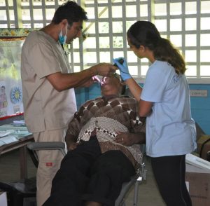 Dr. Dave Apura (left) examines one of his patients with assistance from Tanya Juneya 
