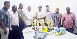 CDC National Director, Eugene Gilbert presents one of the many trophies to DREO of Region 8, Gavin Ganga  who is also one of the organisers for North Pakarimas Sports and Culture Association Summer Fiesta.