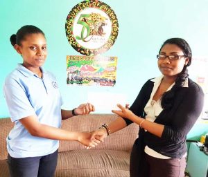 A representative of Jumbo Jet (right) receives the sponsorship  cheque from a representative of Alki Investment Incorporated.