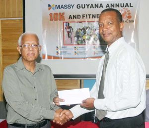 Massy’s Chairman, Deo Persaud (left) hands over the sponsorship cheque to AAG President, Aubrey Hutson.