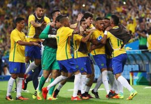 Neymar gets mobbed by his teammates after scoring on a free kick. (Getty Images)