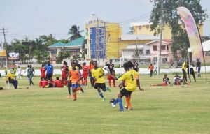 Players from Pele (yellow) and Fruta Conquerors battle for possession at the GDF ground yesterday.
