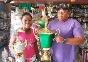 Tiana Lovell of the Trophy Stall presents the President Cup and champion jockey trophy to Wayne Campayne of the President’s Cup organising committee.