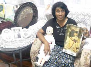 Lucille Bacchus with her daughter’s dolls.  The clock nearby shows the exact time that a drunken driver struck down her children. 