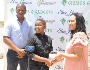 Gizmos and Gadgets Sales Manager Sophia Dolphin presents the smart phone to Kaysan Ninvalle in the presence of GTTA president Godfrey Munroe.