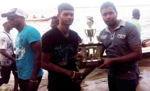 Rawl Pierce of Banks DIH (right) presents the trophy to Lokram Narine of G Square Cavaliers. 