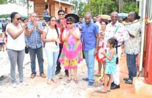 Minister of Social Cohesion Amna Ally, Minister within the Ministry of Public Infrastructure, Annette Ferguson and owner of ACS, Peter Lewis help a young girl cut the ribbon to officially commission the asphalt plant