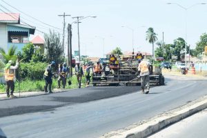 Workers carrying out road-laying duties along the East Bank Demerara Highway yesterday. 