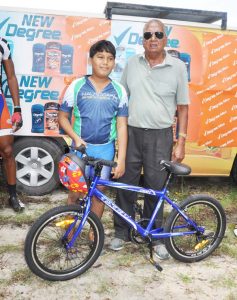 An elated Shay Sue Hang with Hassan Mohamed following the presentation of the Ricks and Sari Agro Industries Ltd. sponsored cycle and helmet.
