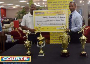 Marketing Manager of Courts Pernell Cummings (left) hands over the cheque to President of the Athletic Association of Guyana Aubrey Hutson at the entity’s Head Office yesterday.
