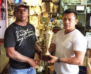 GAPF’s Tyrone Eusibio (right) receives one of the trophies from Trophy Stall’s Sales Rep. 