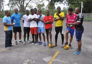 Inter Guiana Goodwill Games Local Coordinator Seon Erskine (left) seen with Futsal Coaches and some of the players on Saturday last at the Cliff Anderson Sports Hall Tarmac.