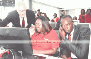 New Digicel Chief Speed Officer Usain Bolt (right) responding to queries from a customer with the assistance of agent Michelle McLean and CEO David Butler on his first day at work Tuesday. (Photo: Garfield Robinson) 