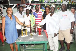  Members of the Pieces Dominoes team with the trophies up for grabs.