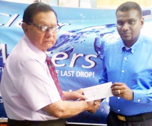 KMTC Chairman, Justice Kennard (left) accepts First prize Cheque From Mr. A. Hardat, Marketing, Sales & Distribution Manager of Clear Waters.