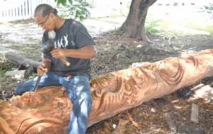 Guyanese sculptor Winslow Craig at work on the totem pole.