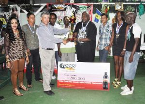F & H skipper Allan Hinds (right) accepts the runner-up prize from Guyana Beverage Inc General Manager Mark Telting in the presence of his teammates. 