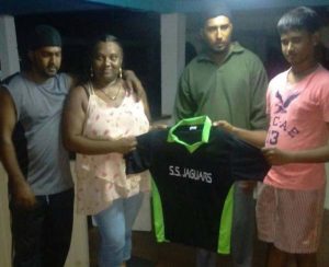 Natasha Persaud presents one of the jerseys to Sans Souci Jaguars wicket-keeper Rashaad Rasheed in the presence of Krishna Persaud (left) and SS Jaguars vice captain Safraz Mohamed.