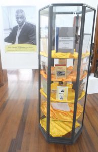 The glass case displaying books by the late Dr. Denis Joseph Ivan Williams