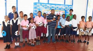 Co-Director of the Petra Organisation Troy Mendonca (centre) addresses the gathering during the presentation of footballs to participating schools yesterday.